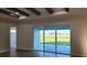 Bright living room with beamed ceiling, complemented by sliding glass doors overlooking the backyard view at 5211 Lake Venice Dr, Wimauma, FL 33598