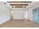 Spacious living room featuring beamed ceilings, white walls, and light wood flooring at 5211 Lake Venice Dr, Wimauma, FL 33598
