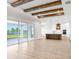 Open living space with beamed ceilings, leading to a kitchen, and a screened outdoor space at 5211 Lake Venice Dr, Wimauma, FL 33598