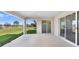 Covered outdoor patio with open view of grassy lawn, pond, and nearby trees at 5211 Lake Venice Dr, Wimauma, FL 33598