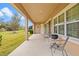 Covered back patio with seating area and a grill, overlooking a spacious, well-maintained lawn at 6307 Brevada Ln, Apollo Beach, FL 33572