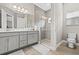 Bright bathroom with double vanity, framed mirrors and an elegant glass enclosed shower with hexagon mosaic tile at 6307 Brevada Ln, Apollo Beach, FL 33572