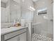 This bathroom features gray tiled walls, double vanity, framed mirror and elegant glass enclosed shower with mosaic floor at 6307 Brevada Ln, Apollo Beach, FL 33572