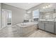 Serene bathroom featuring a soaking tub, double vanity, and elegant tile work for a spa-like experience at 6307 Brevada Ln, Apollo Beach, FL 33572
