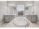 Elegant bathroom features a soaking tub, dual vanities, and a large window at 6307 Brevada Ln, Apollo Beach, FL 33572