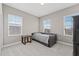 Neutral bedroom with two windows, a bed, and a dark wood side table at 6307 Brevada Ln, Apollo Beach, FL 33572