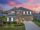 Charming two-story home with landscaped front yard and a two car garage with beautiful sunset at 6307 Brevada Ln, Apollo Beach, FL 33572