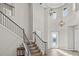 Grand two-story foyer with hardwood floors, decorative lighting, and a staircase with iron railing at 6307 Brevada Ln, Apollo Beach, FL 33572