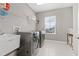 Functional laundry room equipped with a sink, shelving, and modern washer and dryer units at 6307 Brevada Ln, Apollo Beach, FL 33572