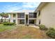 Two-story condo featuring a screened lanai, backyard, and lush landscaping at 7300 Sunshine Skyway S Ln # 108, St Petersburg, FL 33711