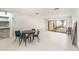 Bright living room with white tile, dining table, and large sliding doors to outdoor area at 7300 Sunshine Skyway S Ln # 108, St Petersburg, FL 33711