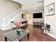 Bright living room with hardwood floors, a large tv, and a staircase at 8811 Casablanca Way, Tampa, FL 33626