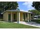 Side view of a house with a covered entry and tidy lawn in a residential neighborhood at 11798 104Th St, Largo, FL 33773