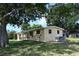 Rear view featuring a well-maintained lawn and air conditioning unit at 11798 104Th St, Largo, FL 33773