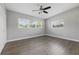 Bedroom with three windows, ceiling fan, neutral paint and wood-look flooring at 1415 Ridge Ave, Clearwater, FL 33755