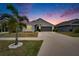 Exterior twilight view of well-maintained home featuring manicured lawn at 14525 Scottburgh Glen Dr, Wimauma, FL 33598