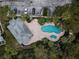 Aerial view of the community pool, parking, and partial building with patio area and lounge chairs at 1946 Hammocks Ave, Lutz, FL 33549