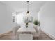 Elegant dining room with modern lighting, seating for six, and bright natural light at 1946 Hammocks Ave, Lutz, FL 33549