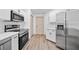 Modern kitchen with stainless steel appliances, ample cabinetry, and wood-look flooring at 1946 Hammocks Ave, Lutz, FL 33549