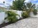 Fenced backyard area with stone flooring and tropical landscaping at 410 W Lemon St, Tarpon Springs, FL 34689