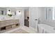 Modern bathroom with dual sinks, marble floors, and a soaking tub visible through a glass door at 16403 Zurraquin De Avila, Tampa, FL 33613