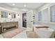 Primary bathroom with dual vanities, soaking tub, and view to bedroom sitting area at 16403 Zurraquin De Avila, Tampa, FL 33613