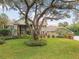 Beautiful home showcasing a mature tree, lush landscaping, and a stone facade at 16403 Zurraquin De Avila, Tampa, FL 33613
