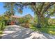 Stately home featuring stone accents, a circular driveway, and mature landscaping at 16403 Zurraquin De Avila, Tampa, FL 33613