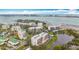 Expansive aerial view showcasing waterfront condo, Tampa Bay, gulf beaches, and verdant landscaping at 220 Belleview Blvd # 101, Belleair, FL 33756