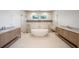 Bright bathroom featuring double vanities, a soaking tub, and a walk-in shower with marble tile at 2622 N Dundee St, Tampa, FL 33629