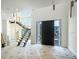 Bright entryway featuring a modern front door, a floating staircase, and large windows, creating an open and inviting space at 2622 N Dundee St, Tampa, FL 33629