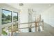 View of an interior staircase with modern lighting fixtures, white walls, and large windows offering abundant natural light at 2622 N Dundee St, Tampa, FL 33629