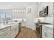 Bright kitchen with stainless steel appliances, white cabinets, quartz counters, and tile backsplash at 3027 Bermuda Sloop Cir, Ruskin, FL 33570