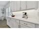 Bright kitchen with white cabinetry, quartz countertops, stainless steel hardware, and subway tile backsplash at 3027 Bermuda Sloop Cir, Ruskin, FL 33570