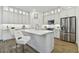 Bright kitchen with an island with seating, white cabinets, stainless steel appliances, and tile backsplash at 3027 Bermuda Sloop Cir, Ruskin, FL 33570
