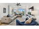 Bright living room with modern decor, plush seating, ceiling fan, and sliding glass doors to a balcony at 3027 Bermuda Sloop Cir, Ruskin, FL 33570