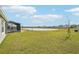 Expansive backyard features a tranquil lake view, green lawn and screened lanai at 31814 Oyster Trellis Ln, Wesley Chapel, FL 33545