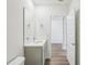 Powder room with vanity and mirror adjacent to hallway at 31814 Oyster Trellis Ln, Wesley Chapel, FL 33545