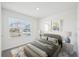 Bright bedroom featuring a comfortable bed, stylish decor, and a large window with neighborhood views at 31814 Oyster Trellis Ln, Wesley Chapel, FL 33545