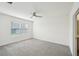Bright bedroom features a ceiling fan, large window, and neutral carpet at 31814 Oyster Trellis Ln, Wesley Chapel, FL 33545