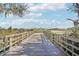 Wooden walkway leading to a serene lake and picturesque views of the community at 31814 Oyster Trellis Ln, Wesley Chapel, FL 33545