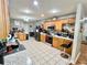 Spacious kitchen featuring stainless steel appliances, white tile floors and light wood cabinets at 37634 Hidden Park Ct, Dade City, FL 33525