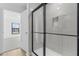 Elegant shower featuring gray tile, built in soap nook, and a seamless glass door at 4621 Kenoska St, North Port, FL 34288