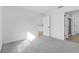 Bright bedroom featuring neutral carpet, crisp white walls, and a view into the hallway at 4621 Kenoska St, North Port, FL 34288