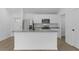 Modern kitchen featuring stainless steel appliances, white cabinets, and a granite-topped island at 4621 Kenoska St, North Port, FL 34288