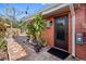 Exterior view of back entrance featuring a black door, brick path, and manicured landscaping at 5166 39Th S St, St Petersburg, FL 33711