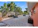 Paver-laid backyard with pool, mature palms, and comfortable seating, ideal for outdoor relaxation and entertaining at 5166 39Th S St, St Petersburg, FL 33711