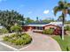 Lovely property showcasing well-kept front yard with landscaped garden, brick driveway, and solar panels on the roof at 5166 39Th S St, St Petersburg, FL 33711