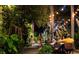 Enchanting outdoor dining area with string lights, lush greenery, and patrons enjoying the evening at 5166 39Th S St, St Petersburg, FL 33711