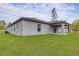 Spacious backyard featuring a covered patio and lush green lawn, perfect for outdoor activities at 7220 Swartburg Rd, North Port, FL 34291